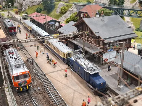 Bahnhof mit Krokodil-Lok und Personenzügen