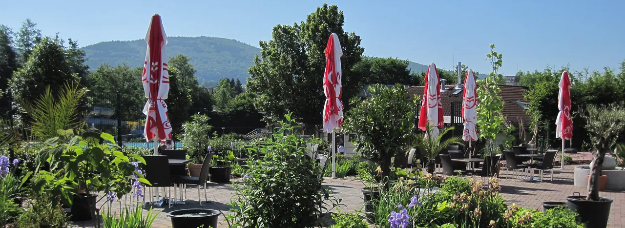 Biergarten unter Sonnenschirmen mit Blick auf den Odenwald